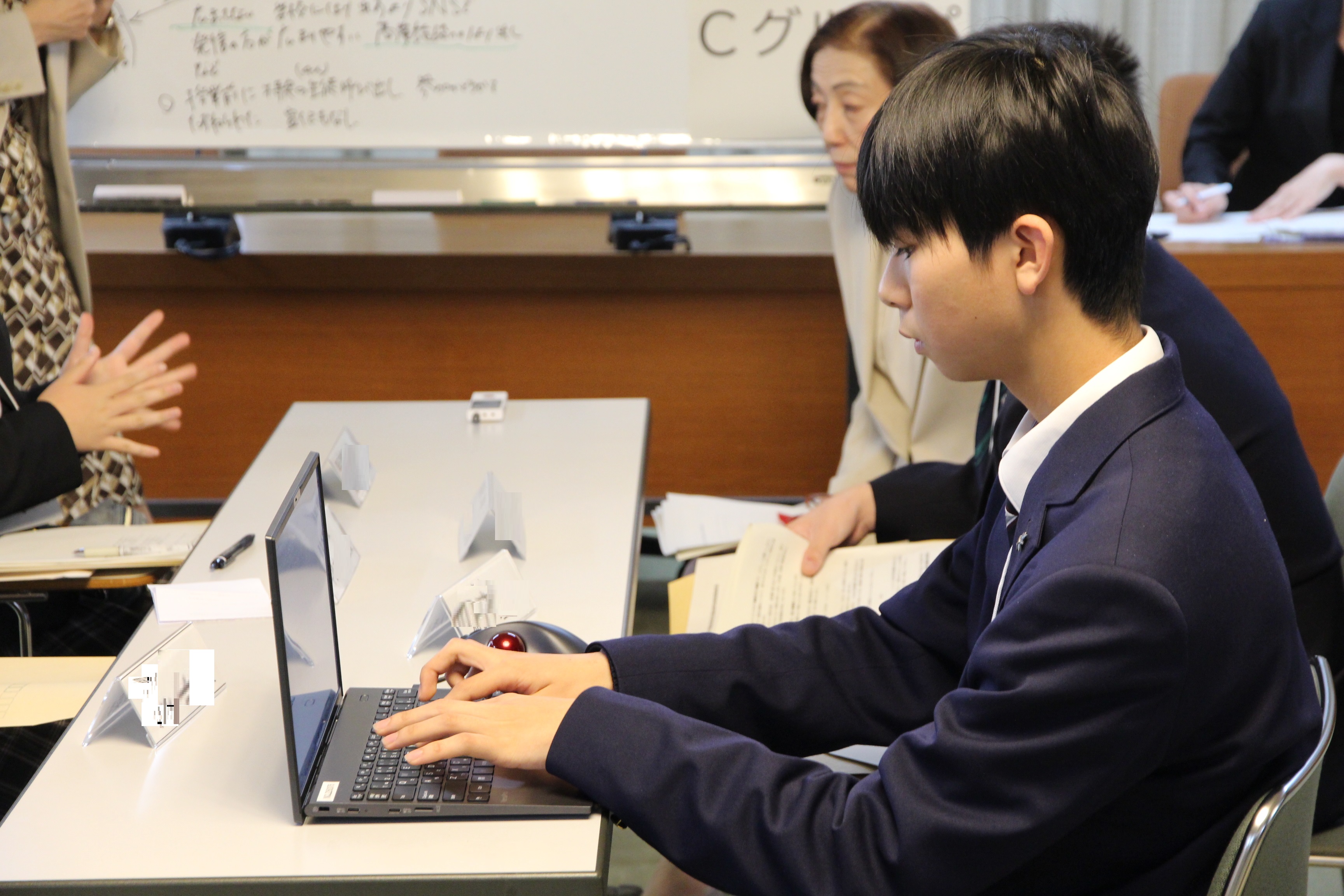 議論の内容をパソコンでまとめる高校生議員