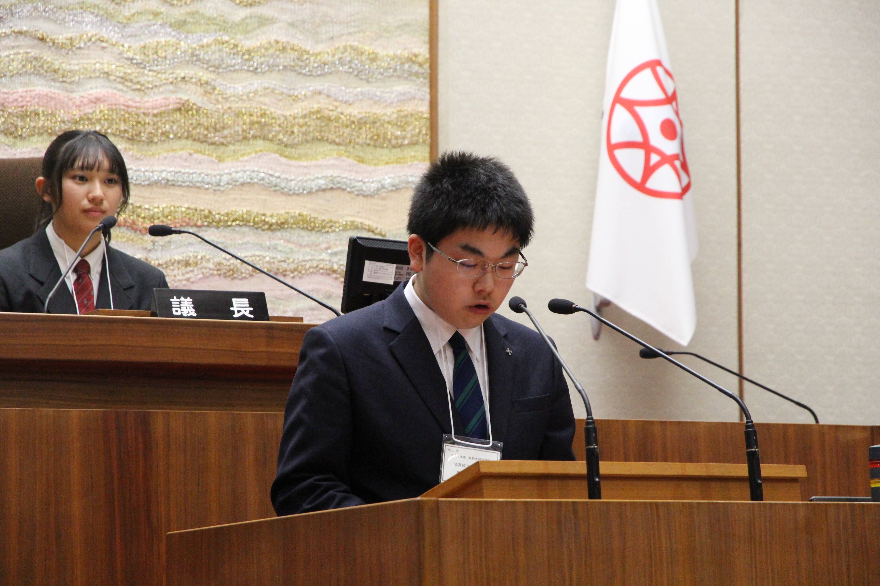 演台に立ちCグループの報告をする高校生議員