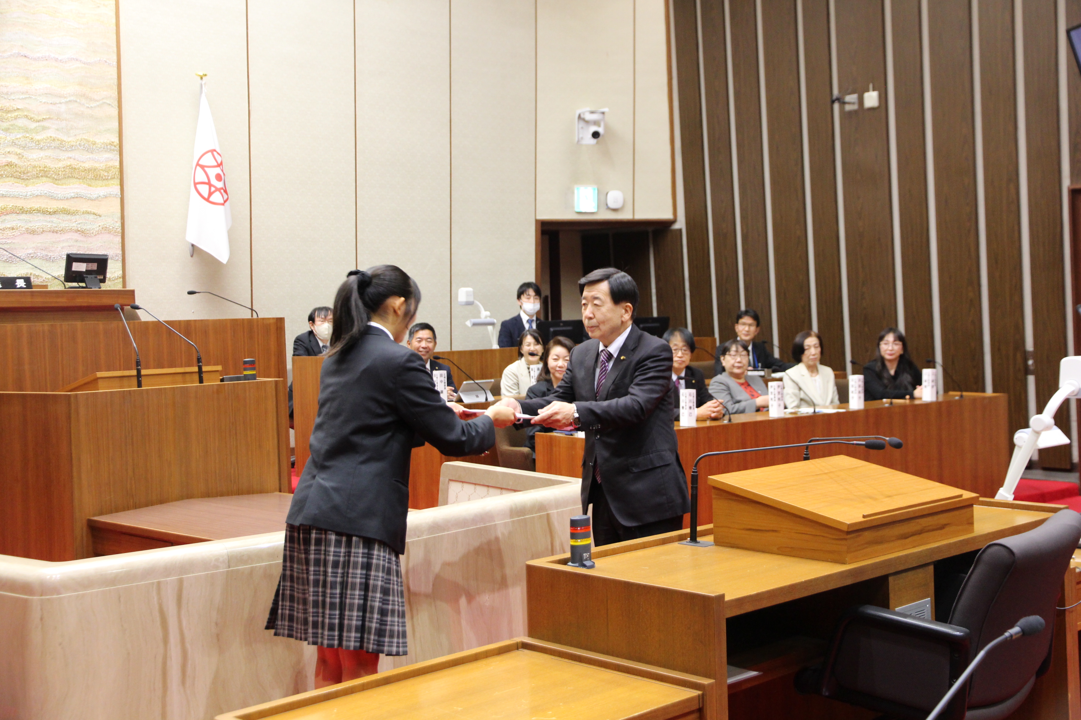 高校生議員へ証明書を手渡す市議会議長